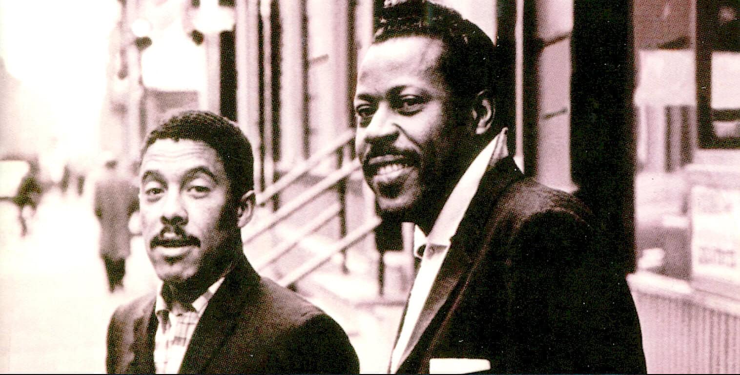 Vintage black and white photo of Malcolm X and Muhammad Ali on a city street, reflecting iconic figures in African American history, civil rights movement, and cultural legacy.