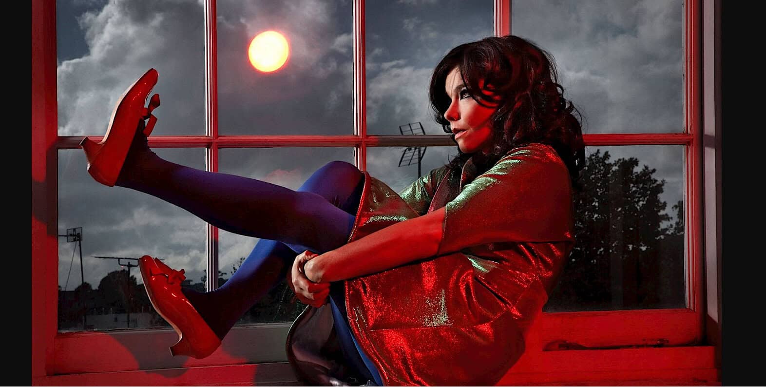 Vintage woman sitting by window with a view of the moon, cityscape, and stormy sky, capturing nostalgic music and news archive vibes, ideal for historical sound archive, soundscape, and music preservation.