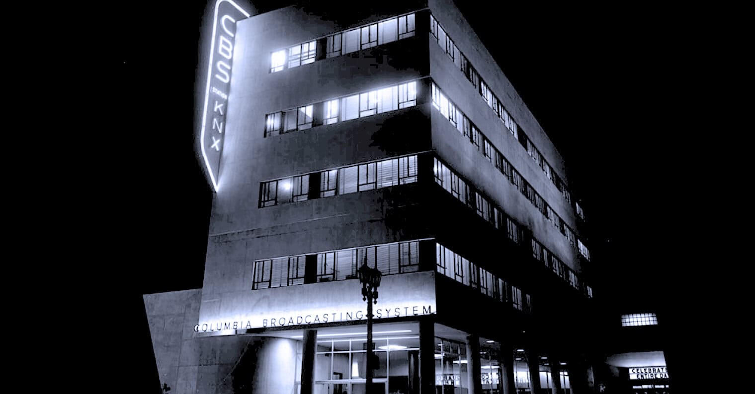 Columbia Broadcasting System (CBS) building at night, iconic media headquarters, illuminated signage, modern architecture, history of broadcasting, news, radio, and music archives.