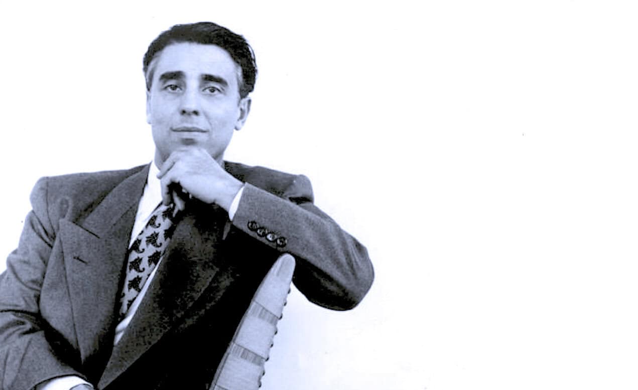 A black and white photo of a man in a suit, representing historic news and cultural archives, useful for historical news and music sound archive content.