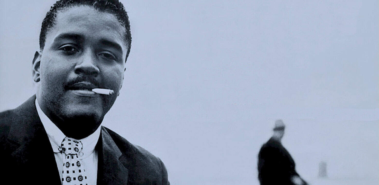 Smoking man in suit with cigarette in mouth in black and white, vintage photo, classic style, historical, urban atmosphere, nostalgia, timeless portrait, black and white photography.