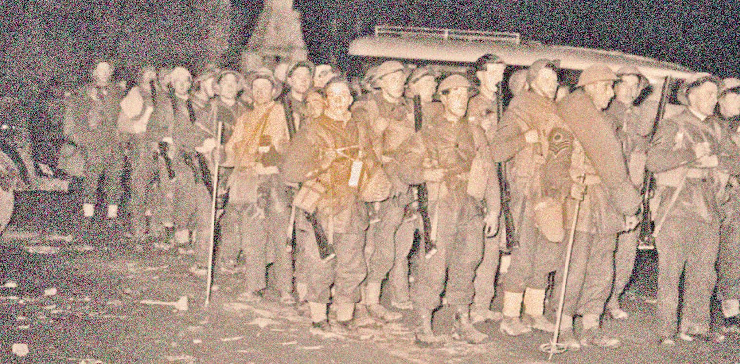 Vintage black and white photo of soldiers marching during WWII, highlighting historical military history, war veterans, and archival news documentation.