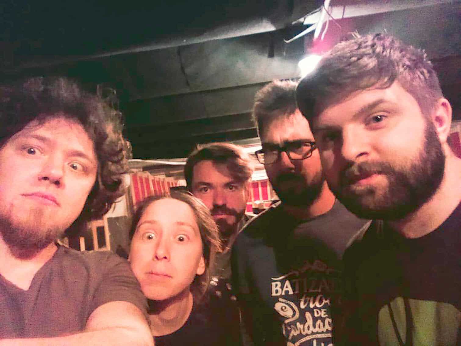 Vintage concert group photo with diverse young adults at a live music venue, showcasing lively atmosphere, music band fans, and social gathering, emphasizing nostalgia for music history and cultural archives.