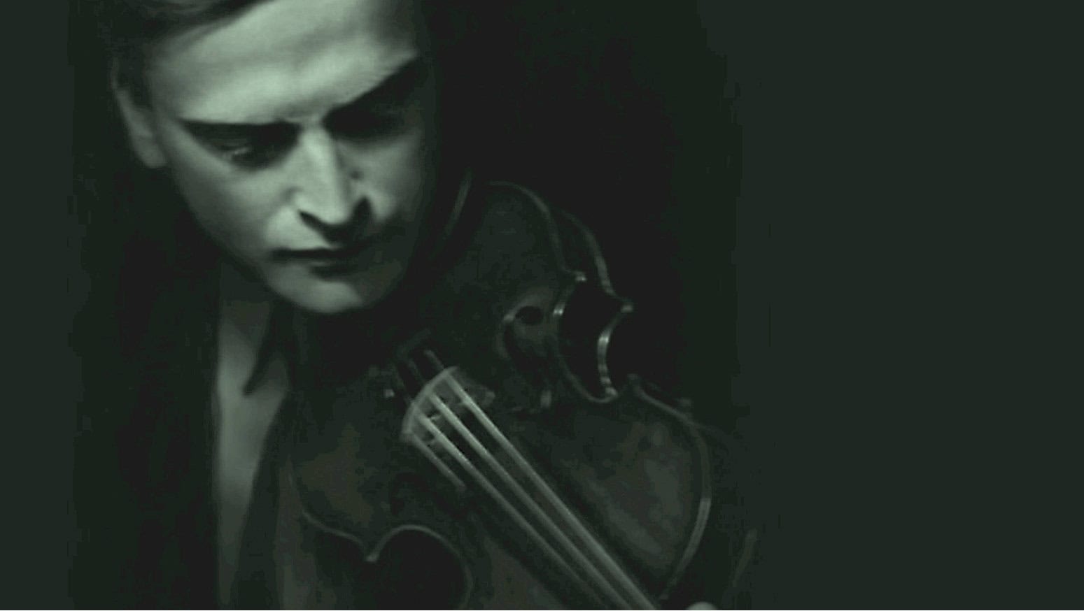 A black and white image of a woman playing the violin with a vintage microphone, emphasizing music, historical recordings, and sound archives.