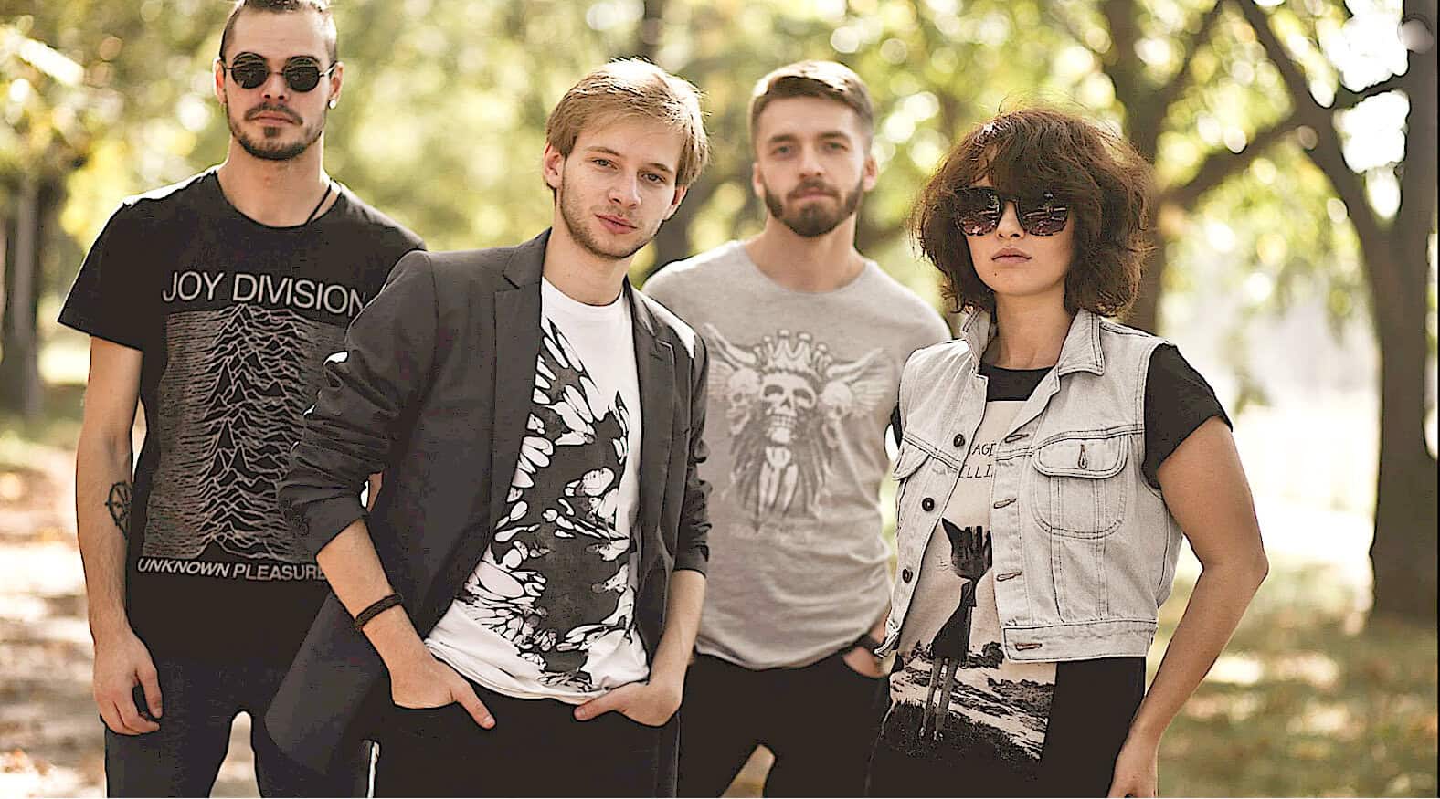 Vintage-inspired indie band members outdoor photo with casual and edgy style, reflecting music, news, and history archives.