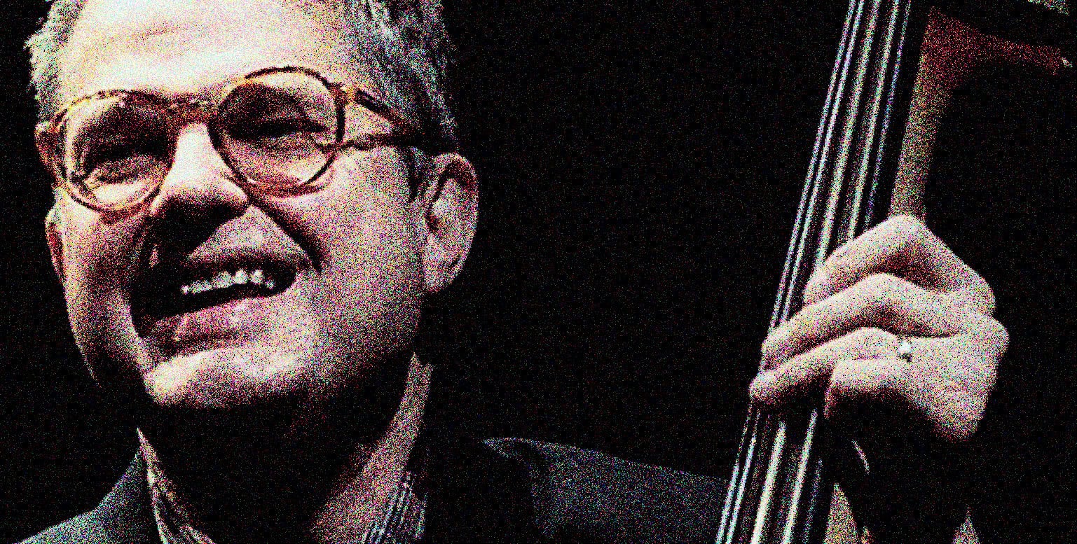Vintage jazz musician playing double bass, captured in a nostalgic, high-contrast black and white photo, emphasizing music history and classic jazz sound archive themes.