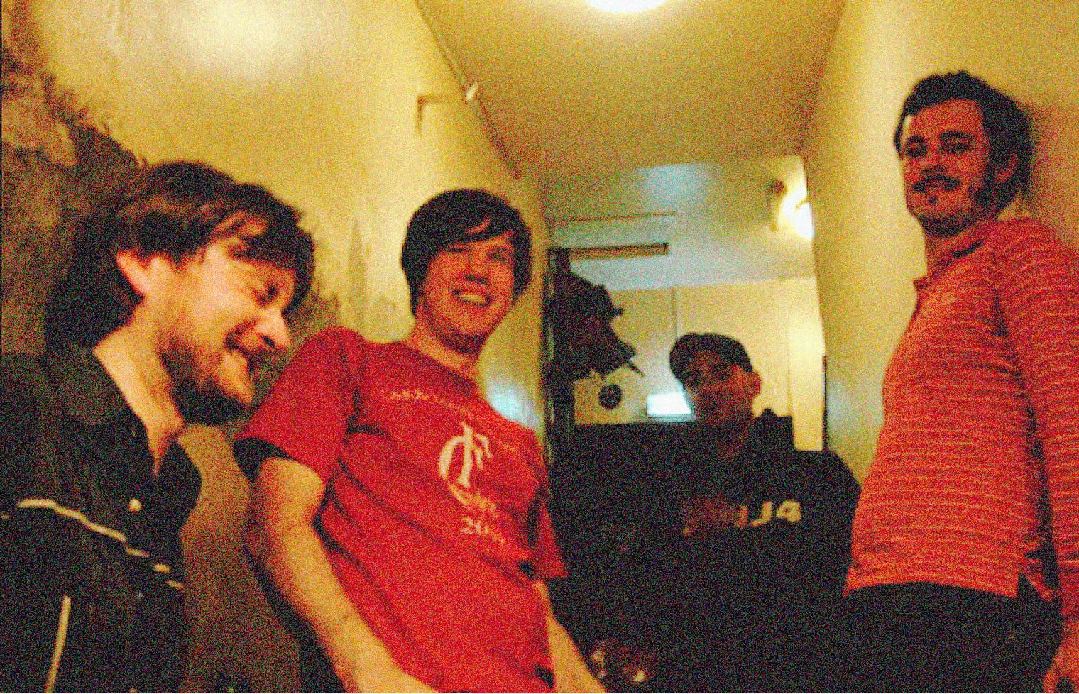 Smiling group of young adults in a casual indoor setting, capturing a fun moment related to music and history, perfect for a sound archive website like Past Daily.