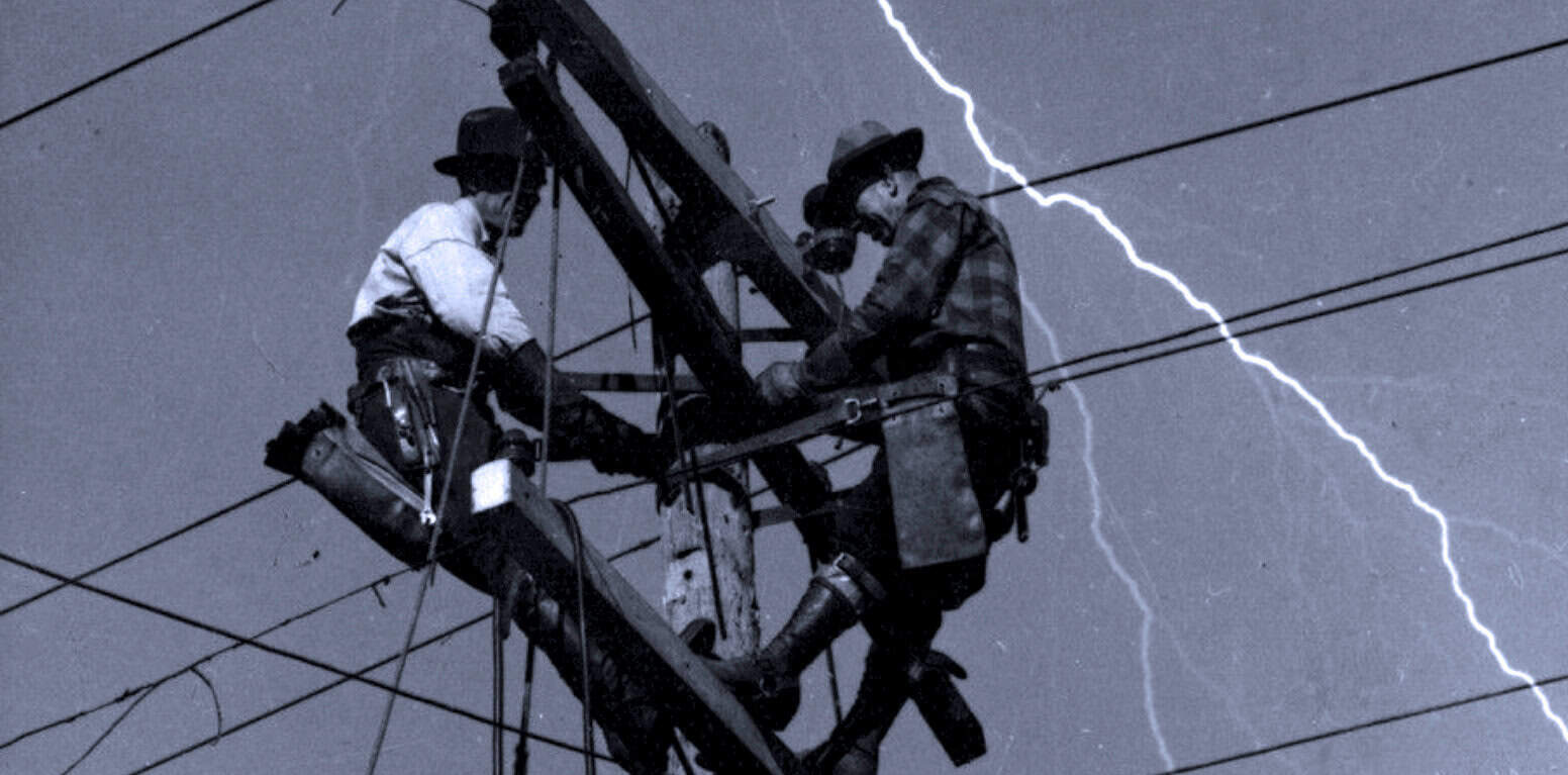 Lightning storm illuminating power line workers repairing during a thunderstorm, showcasing historical news and weather event documentation.