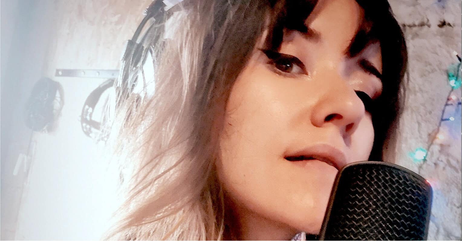 Studio recording of a female singer with microphone and headphones, music, voice, vocals, recording studio ambiance, Past Daily archival content, news, history, and music archive focus.