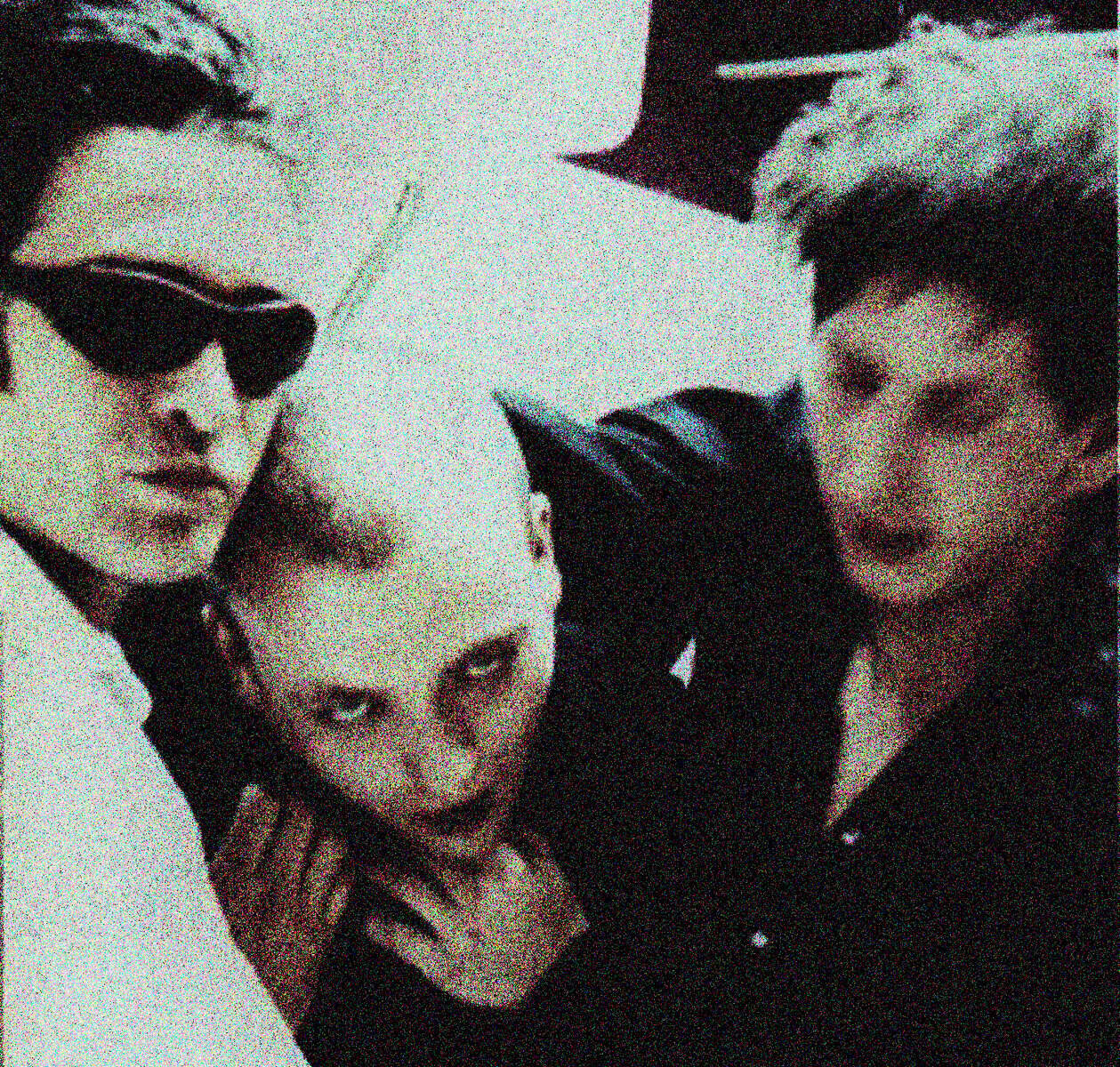 Vintage black and white photo of three punk rock musicians with distinct hairstyles and fashion, capturing a rebellious music scene, perfect for history and music archiving.