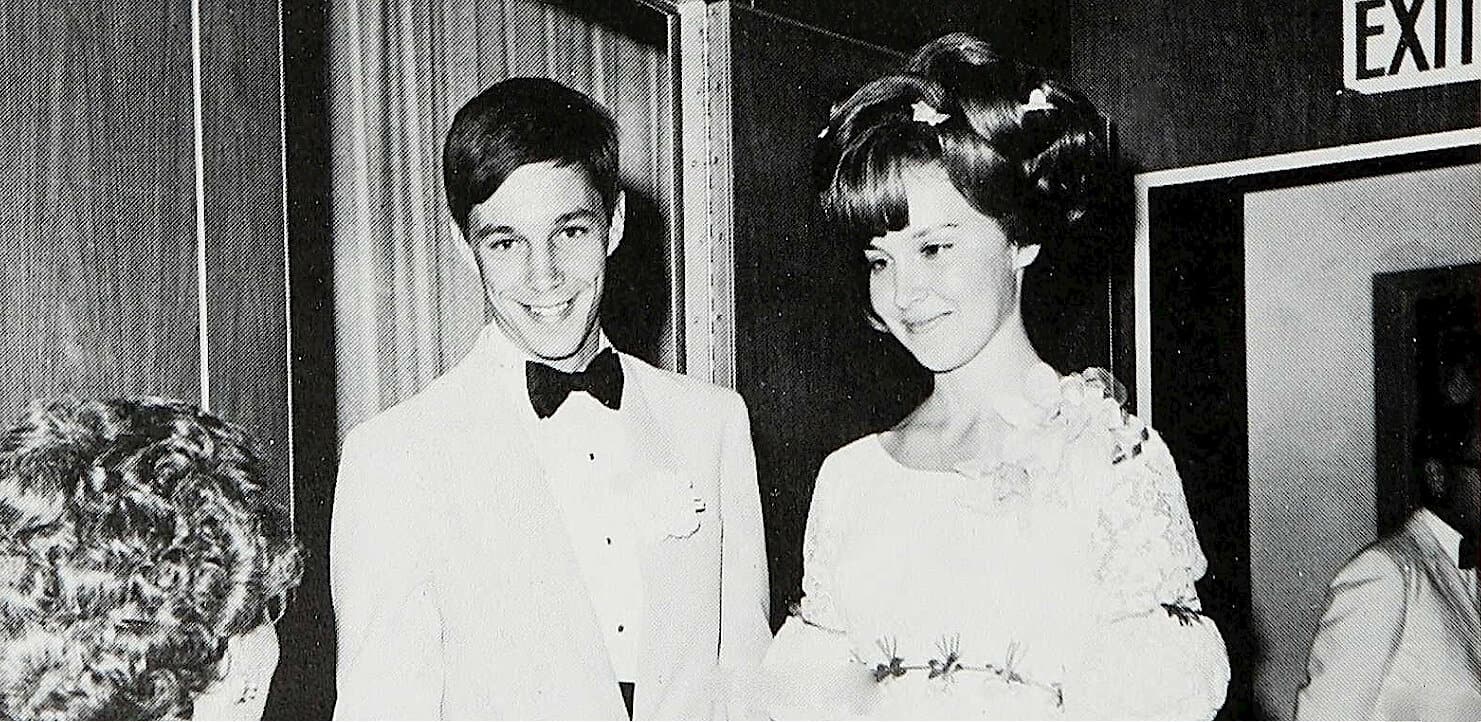Close-up of a young man and woman at a formal event, dressed elegantly, smiling, and posing for photographs, representing archive-worthy moments in news, history, and music.