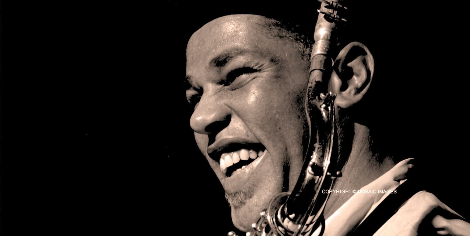 Vibrant black and white portrait of a soulful jazz musician singing passionately while playing the saxophone, capturing the essence of music history and legendary performances.