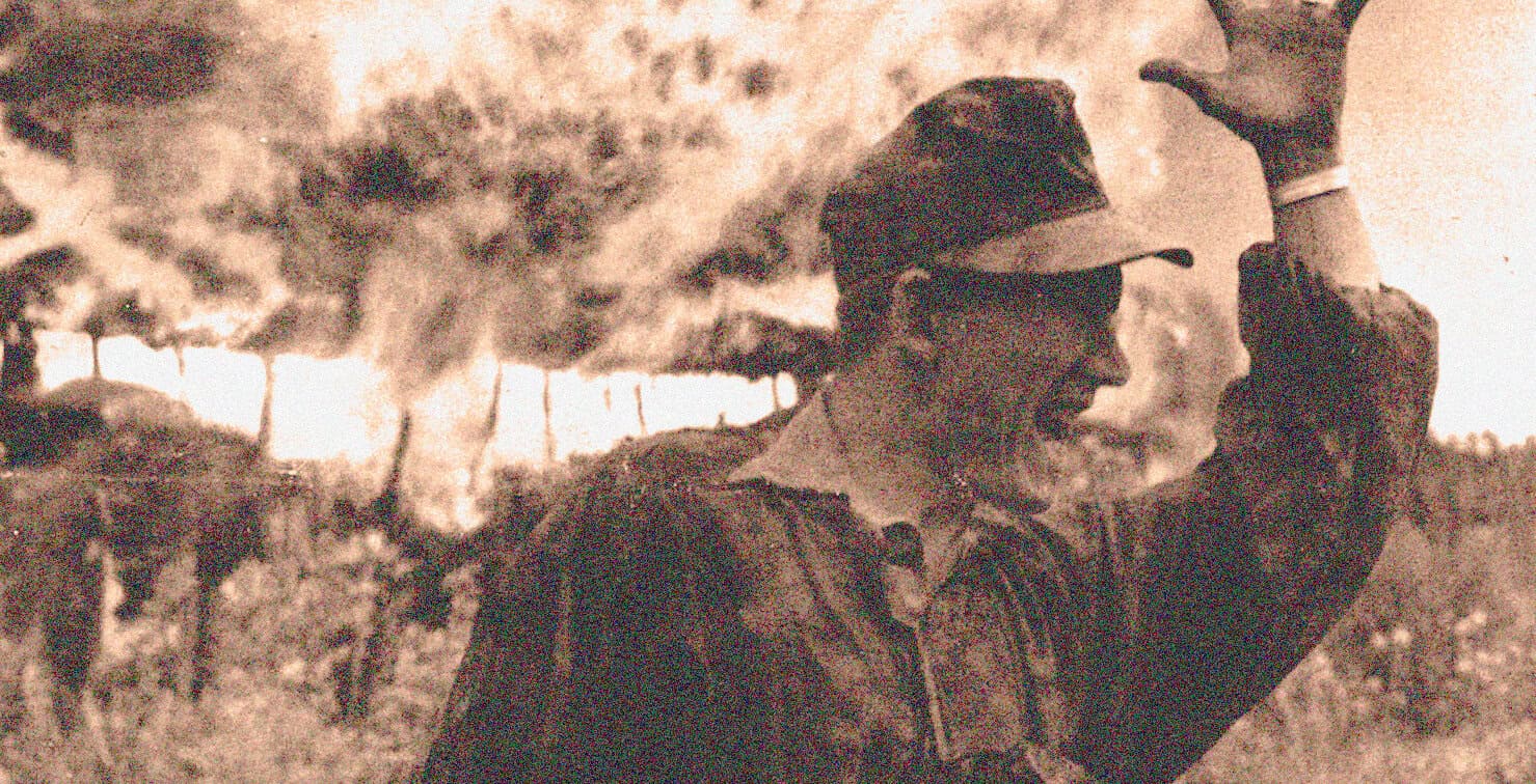 Famous WWII soldier in combat, wearing helmet, amidst explosions and smoke, depicting wartime history, conflict, and heroism, related to historical news and military history archives.