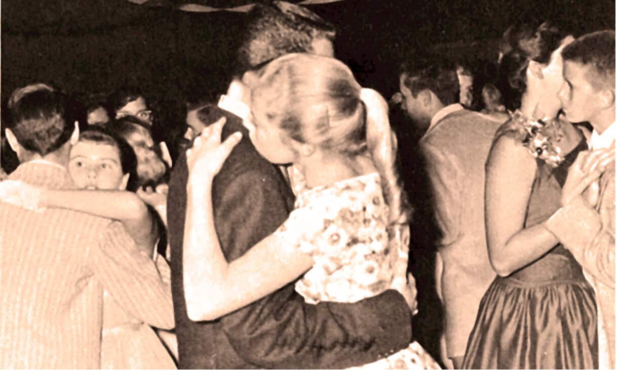 An image of couples dancing closely at a vintage dance event, capturing the nostalgic ambiance of mid-20th century social gatherings with elegant attire and romantic mood.