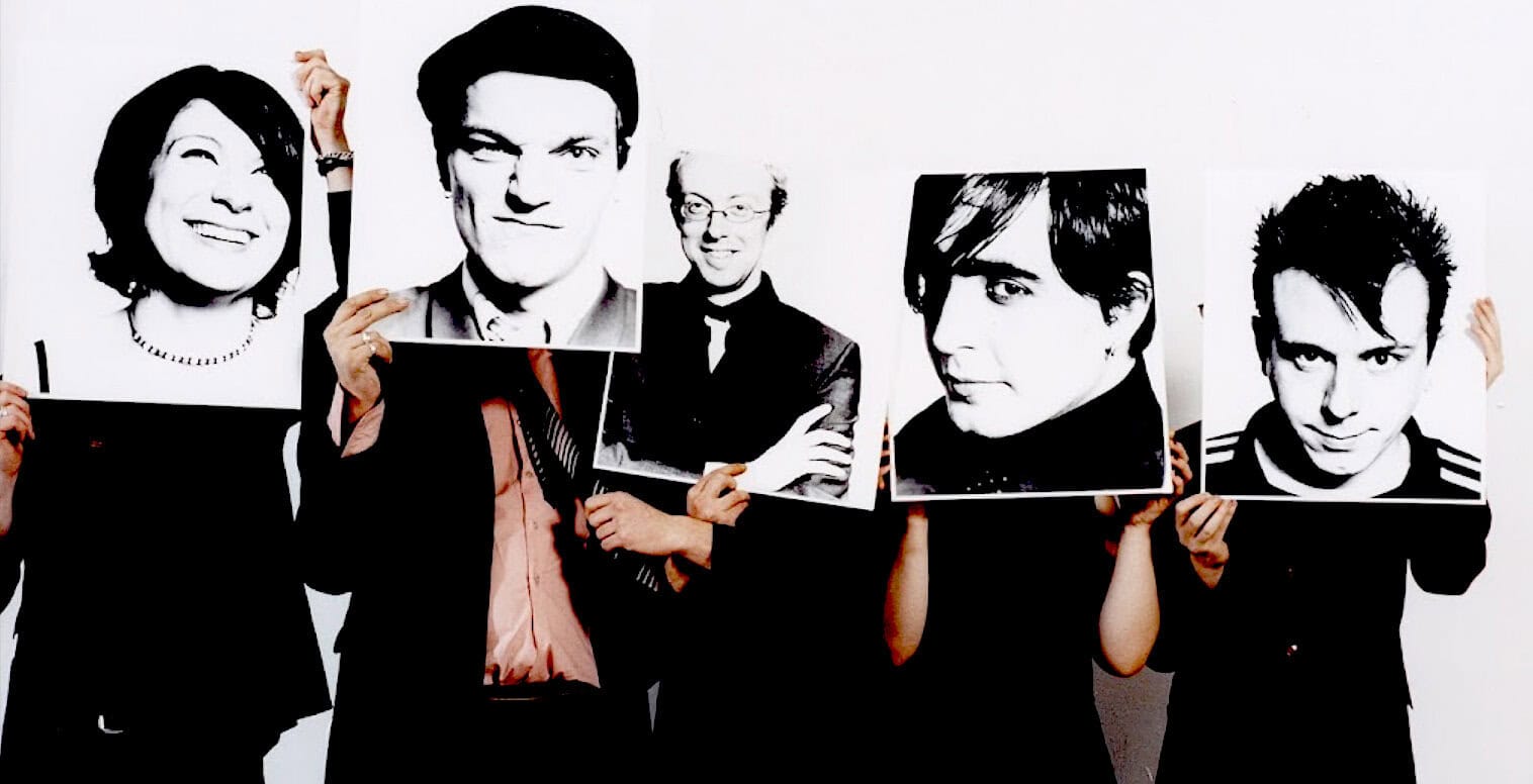 Creatively dressed people holding black-and-white portrait signs, representing news, music, and history in the audio sound archive.