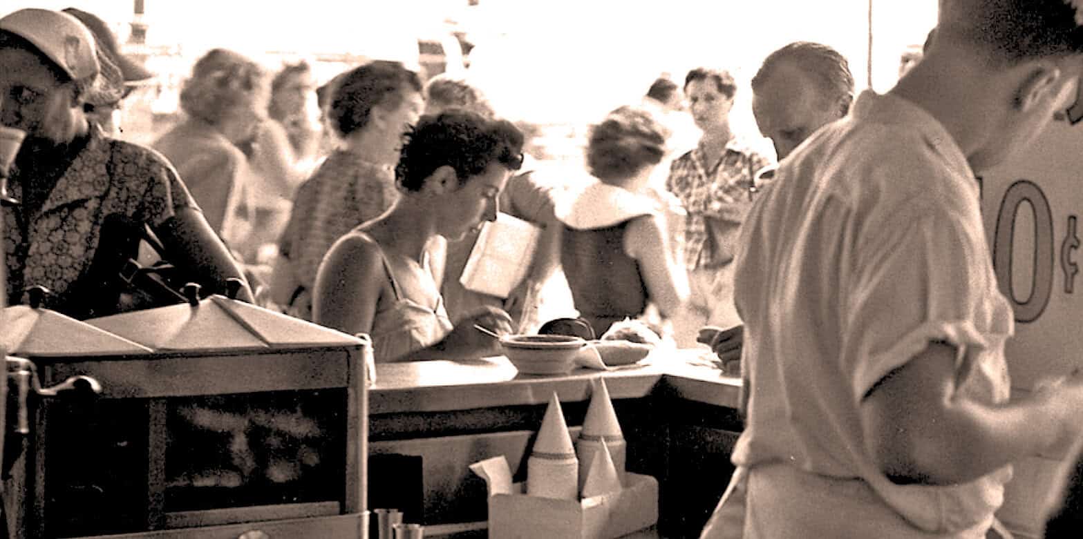 People waiting in line at a food stand or event, vintage black and white photo, summer day, casual clothing, mid-20th century, social gathering | Vintage photo of people waiting in line at a food stand, illustrating mid-20th century social events and community gatherings. Perfect for history, news archives, and cultural storytelling. | Vintage black and white photograph showing people queued at a food stand during a summer day, capturing a moment of mid-20th century community life, nostalgia, lifestyle and social history. | relevance.