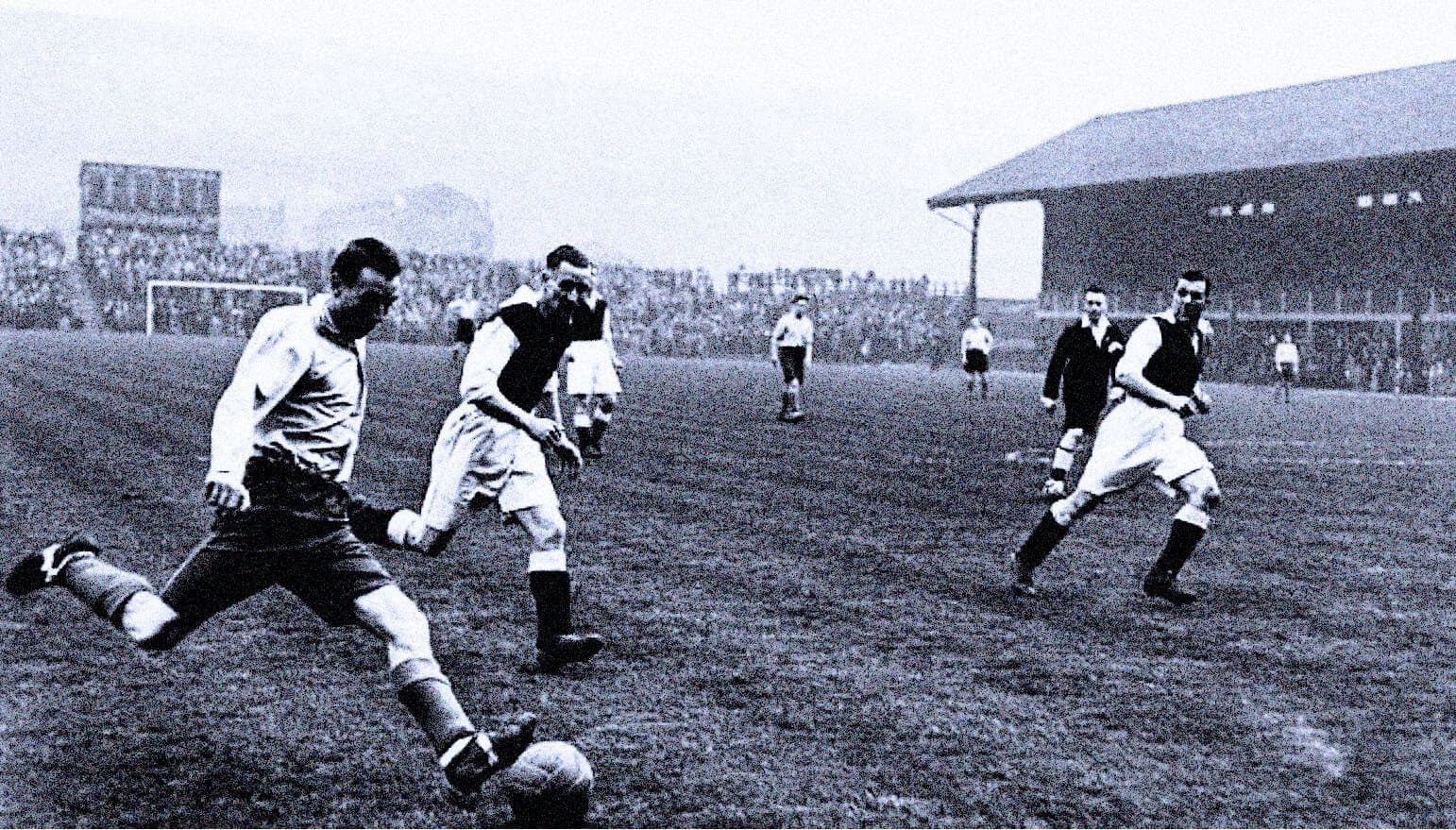 Vintage black and white photo of an early 20th-century soccer match at a stadium, illustrating historic sports events.