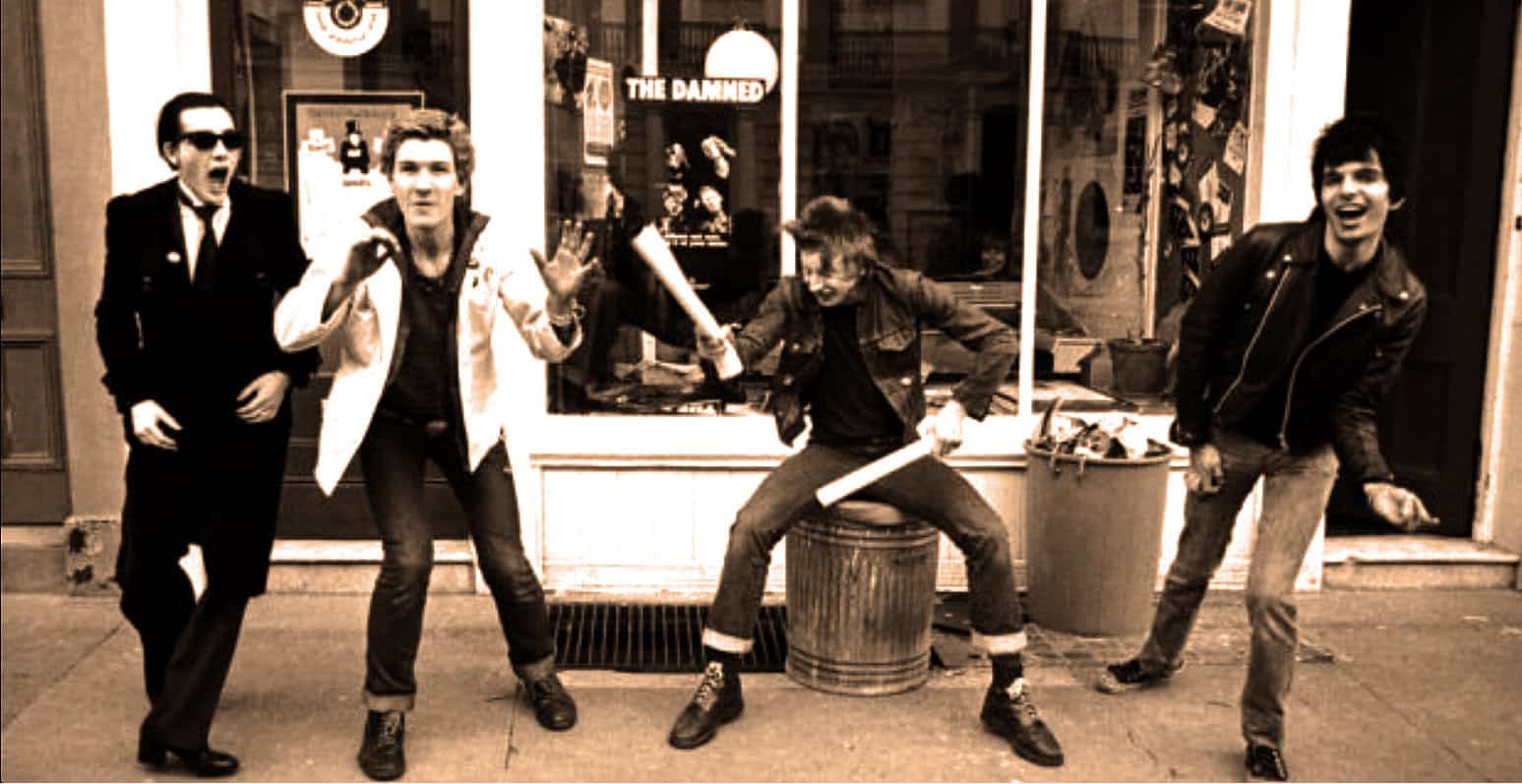 Vintage punk rock band performing on street with energetic poses, black leather jackets, and retro fashion, capturing the rebellious music culture.