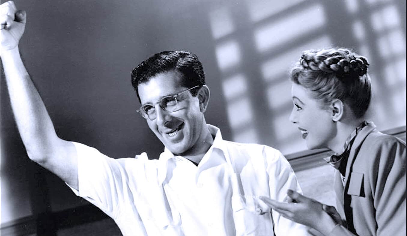 Historian with a woman in a 1950s classroom discussing news, history, and music archives, highlighting vintage education and media preservation.