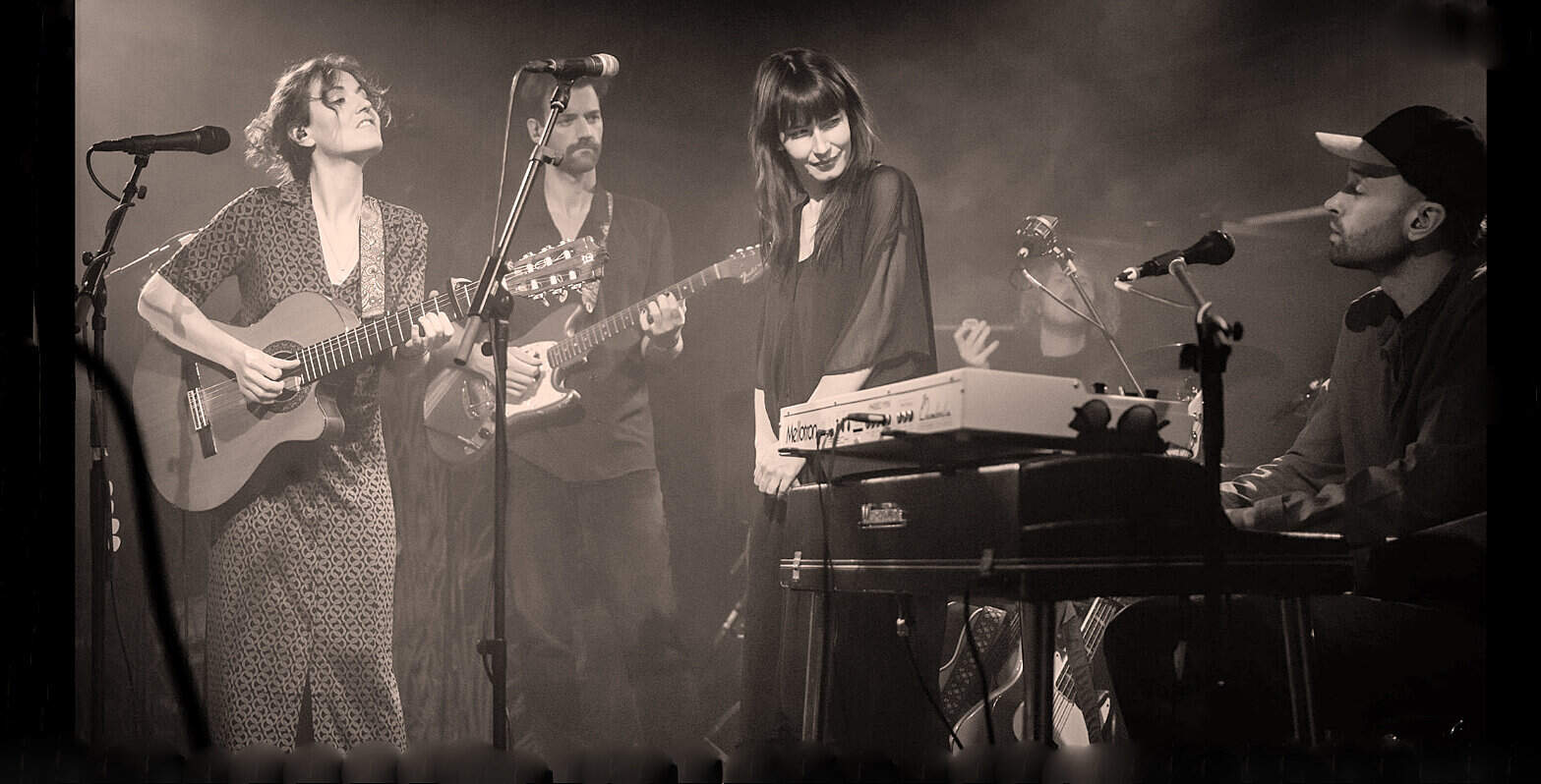Vintage musical performance featuring a female singer, guitarist, and keyboardist in a live concert setting, highlighting live music, artists, and musical instruments.