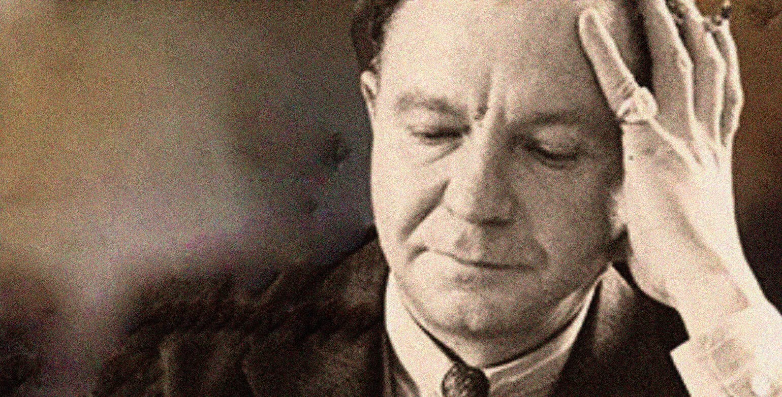 A vintage black and white photo of a man with a distressed expression, holding his head with his hand, symbolizing historical events or news reflections.