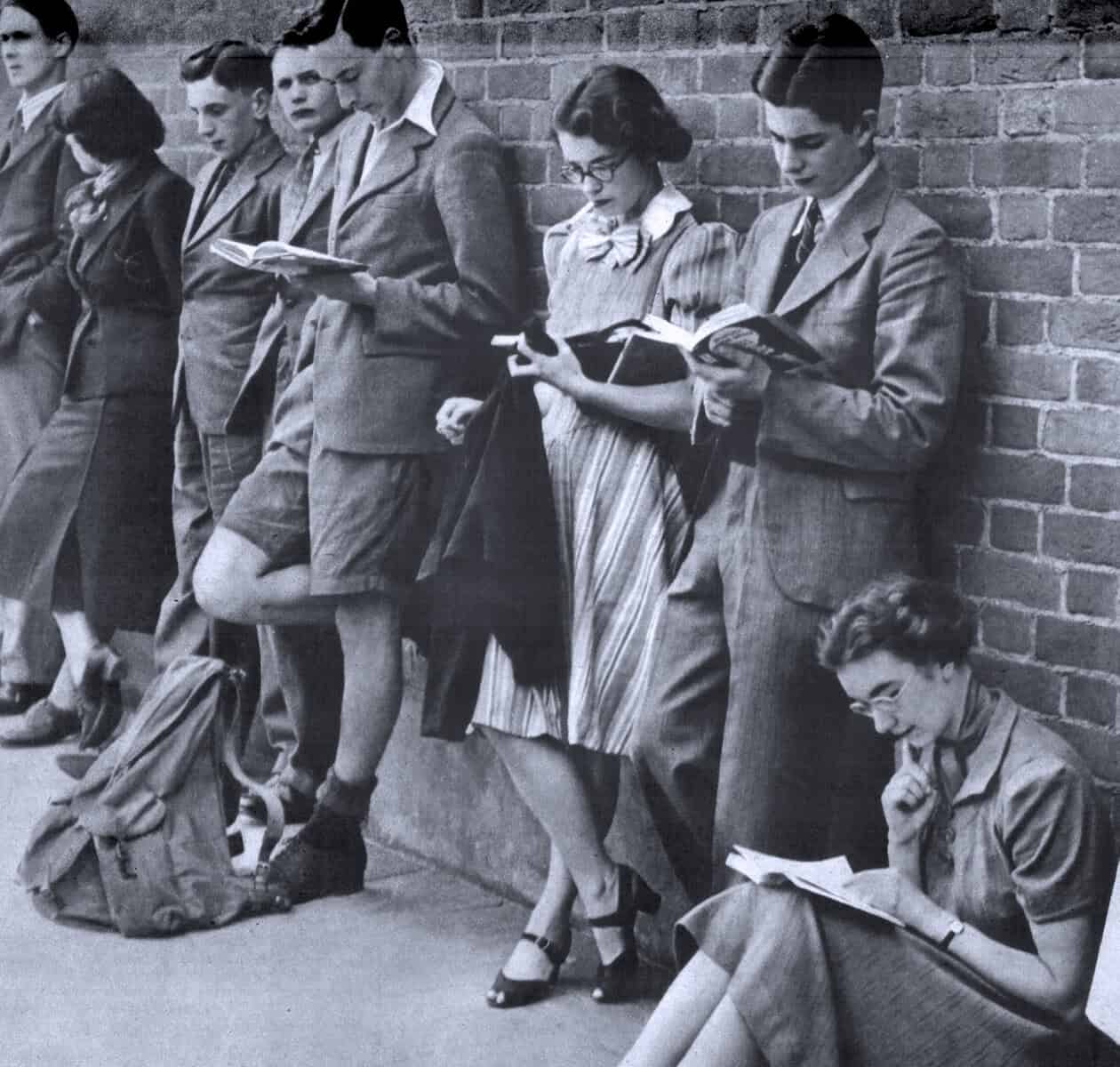 People standing against brick wall reading newspapers and books, vintage black and white photo, news, history, and music archive, historical news gathering scene, Past Daily sound archive.