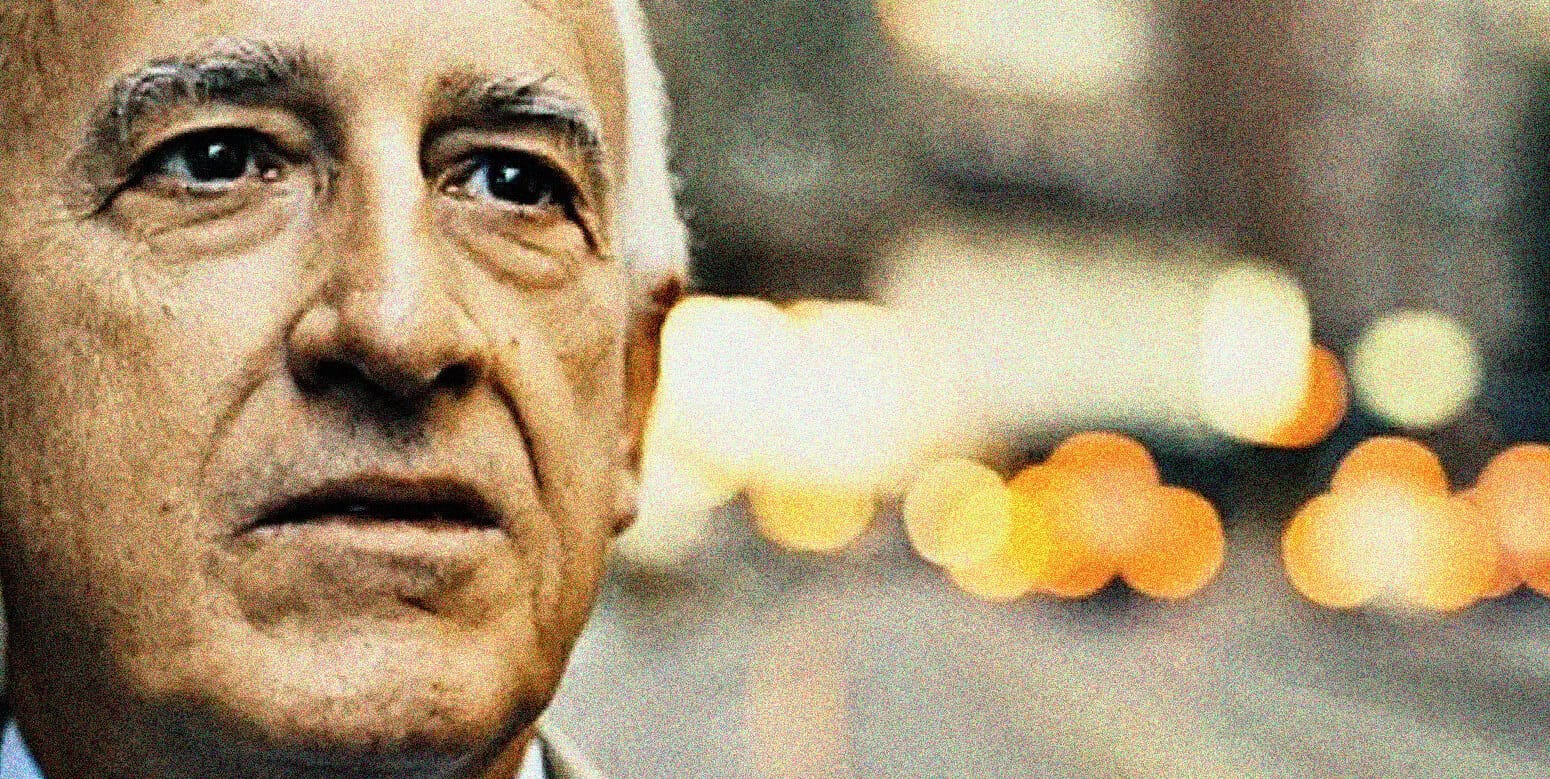 Close-up of elderly man with deep expression, urban night background, news, history, music archive, sound recordings, past daily, multimedia library, historical news footage.