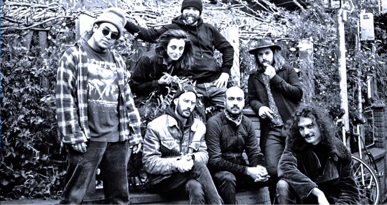 Band of musicians outdoors, black and white photo, alternative and indie rock band, musical group portrait, Past Daily: A Sound Archive of News, History And Music.