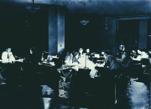 Recording studio personnel working on sound editing and mixing for news, history, and music archives. Vintage setting emphasizing audio preservation and broadcasting history.