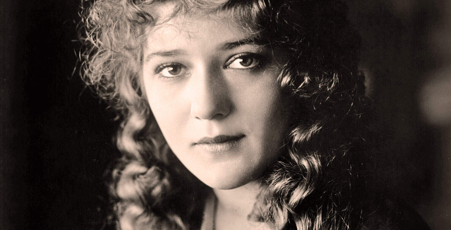 A woman with curly hair, black and white portrait, emphasizing her facial features, expressive eyes, and classic beauty. Ideal for images related to music history, news archives, and cultural preservation.