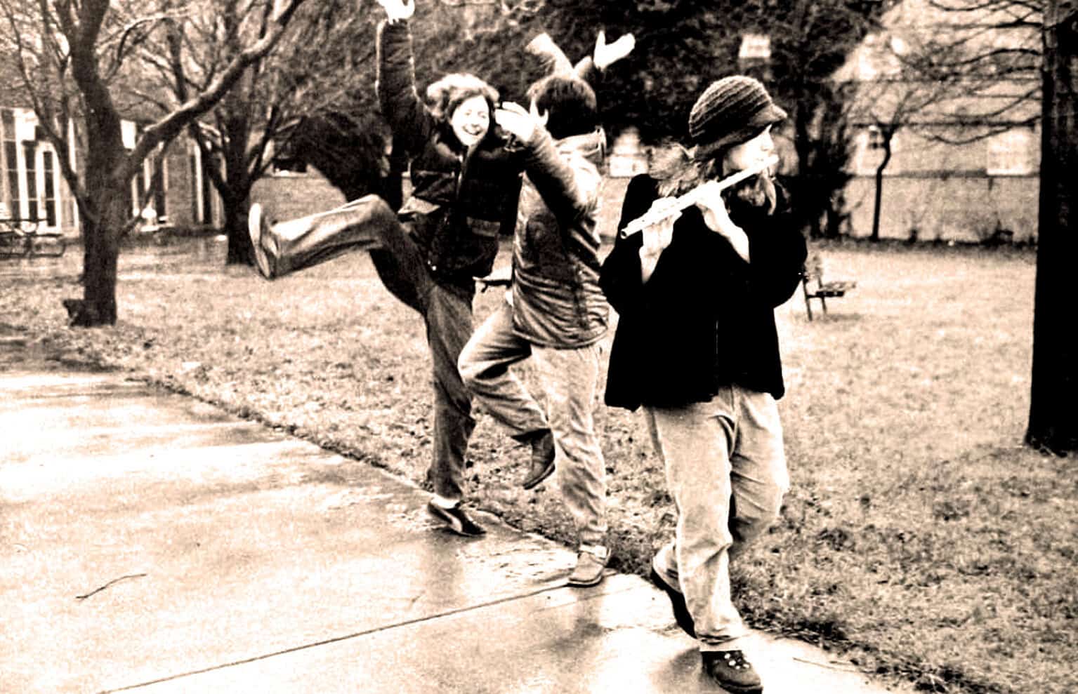 Children playing and enjoying outdoor activities in a park, capturing a joyful moment with vintage black-and-white photo, emphasizing childhood fun and leisure in historical urban settings.