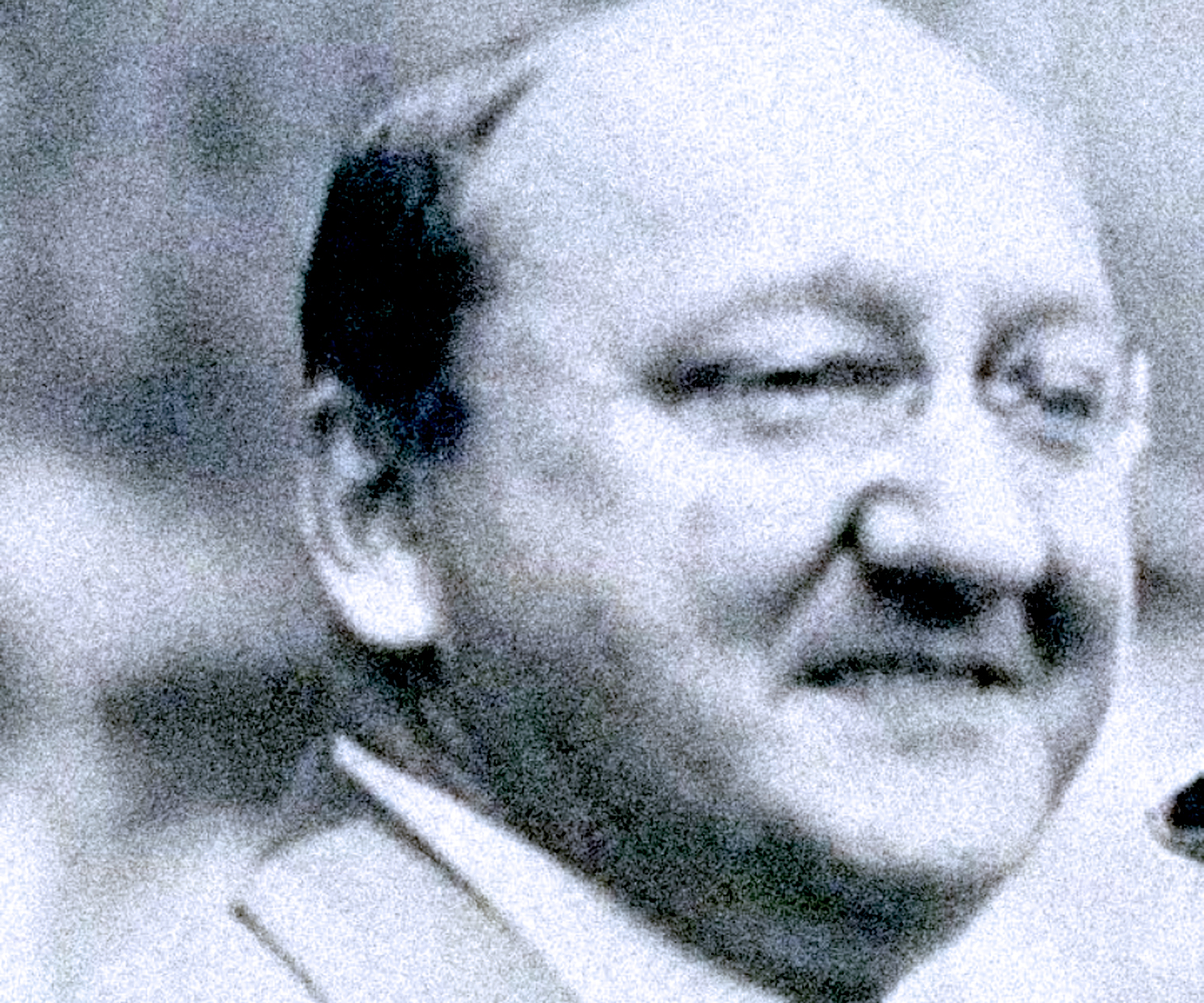 Vintage black-and-white photograph of a smiling man with glasses, representing the history and news archive focus of Past Daily.