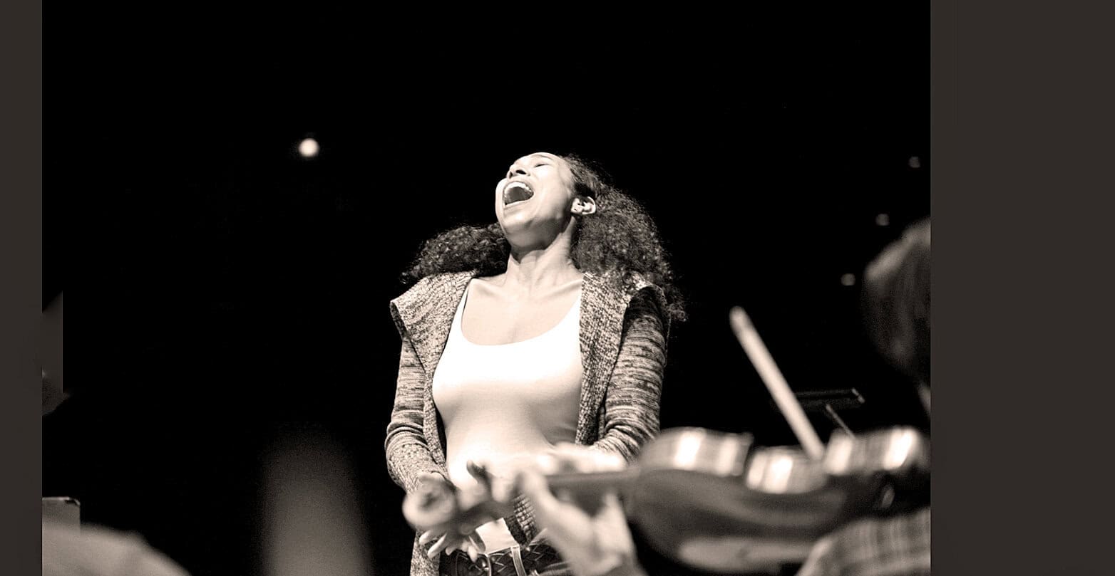 Vocal jazz singer performing passionately, capturing emotion during a live music session, with a focus on preserving music history and sound archives; iconic moment from a jazz concert.