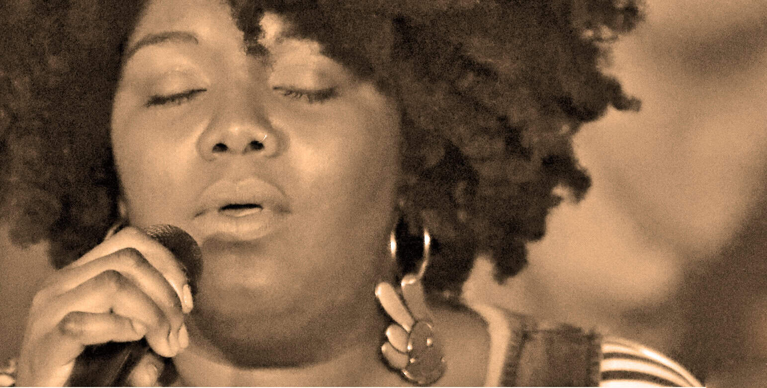Soul singer performing with microphone, vintage music archive, emotional song performance, African American artist, historic music and news recordings, Past Daily archive.