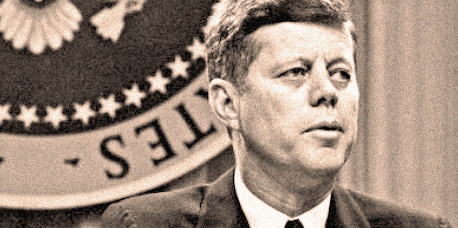 Famous historical figure with short hair speaking in front of the U.S. government seal, representing news history and political speeches, captured from Past Daily archive.