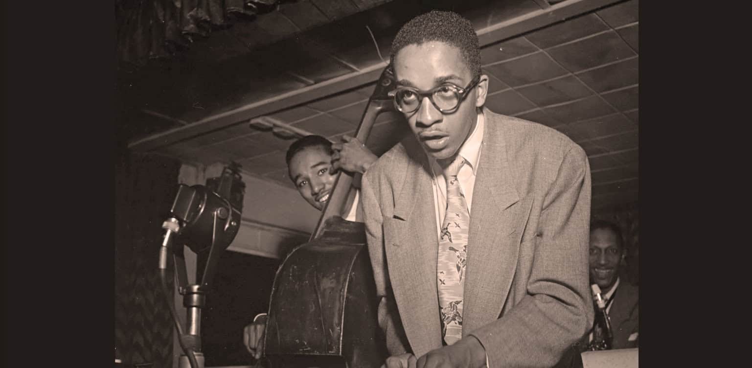 Vintage jazz musician recording session, black and white photo, early 20th century jazz era, vintage music recording equipment, historic music archive, Black musicians, soulful jazz performance, music history.