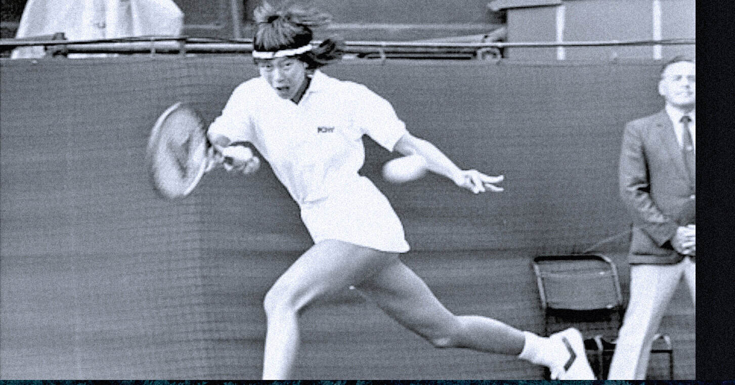 A woman tennis player in action during a match, captured in black and white, showcasing competitive sports history and classic tennis moments.