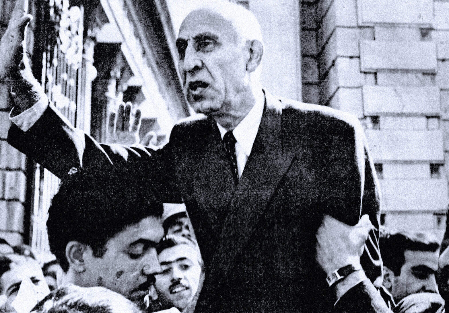 Respected man in suit passionately speaking to crowd outside, historical black and white photo, likely related to news, politics, or social movements, representing key moments in history and journalism.