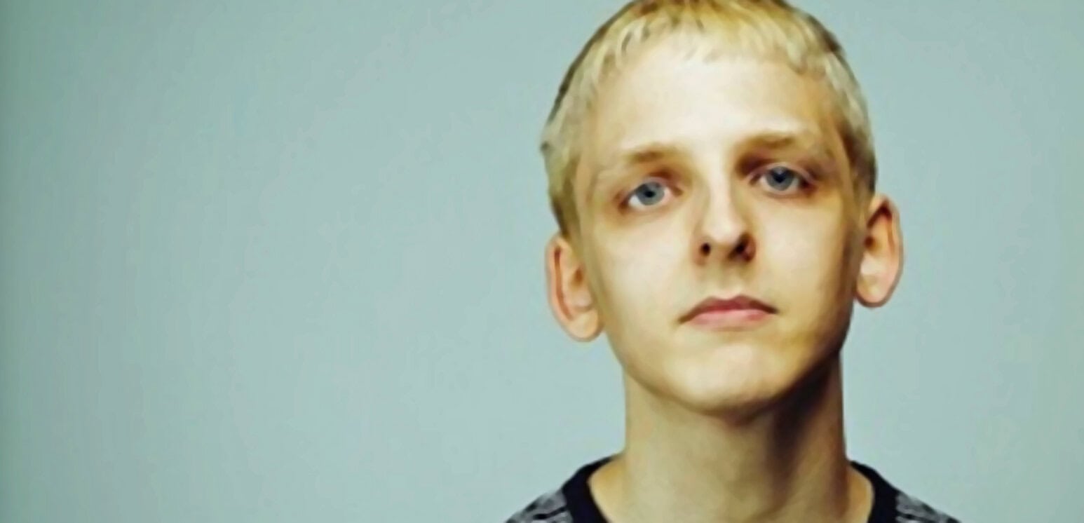 Young man with blonde hair and blue eyes, portrait with neutral background, casual clothing, representing music, news, and history archives.