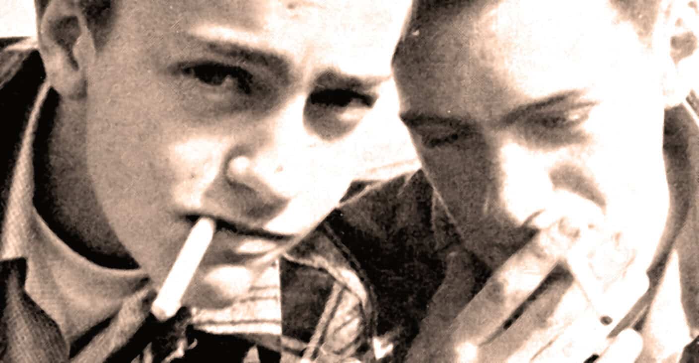 Youthful peers smoking cigarettes, capturing a nostalgic moment reminiscent of mid-20th-century culture and social life.