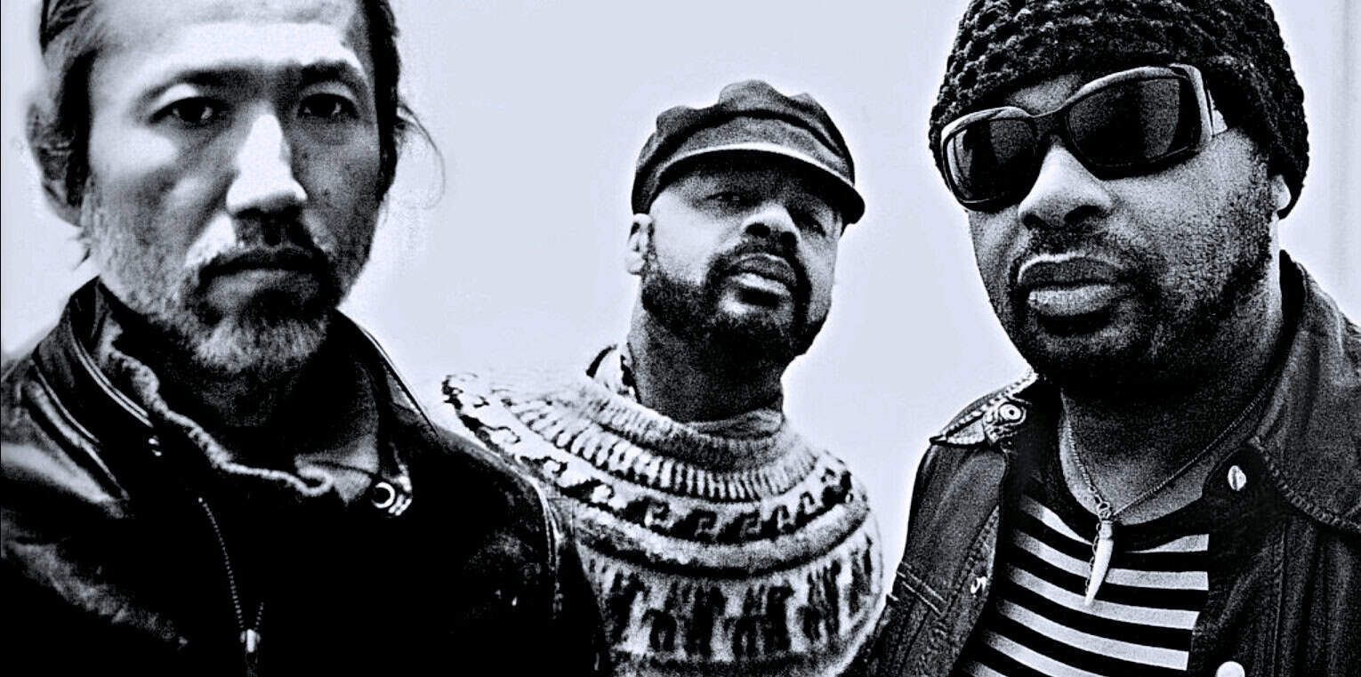 Men wearing sunglasses and stylish clothing, black and white photo, representing iconic music and news history, associated with Past Daily's sound archives, news, and musical heritage.