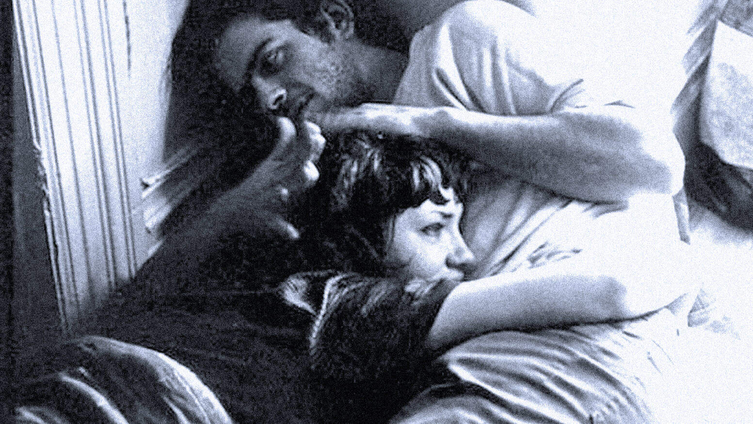 Close-up of a young couple lying on a bed, emphasizing intimacy and emotional connection, representing stories and history captured in a sound archive.