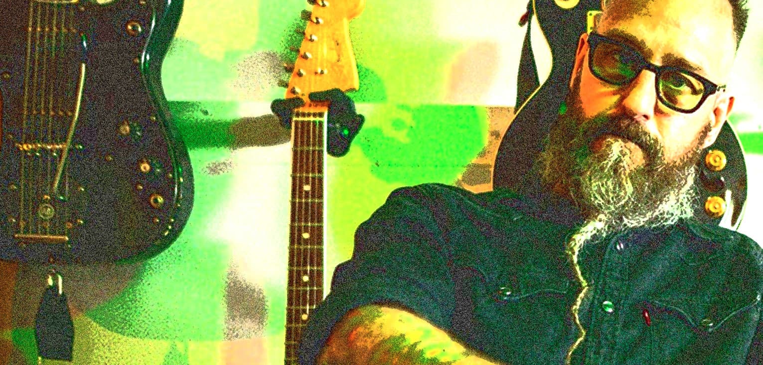 Vintage musician with guitar collection, music history memorabilia, and headphones at Past Daily sound archive.