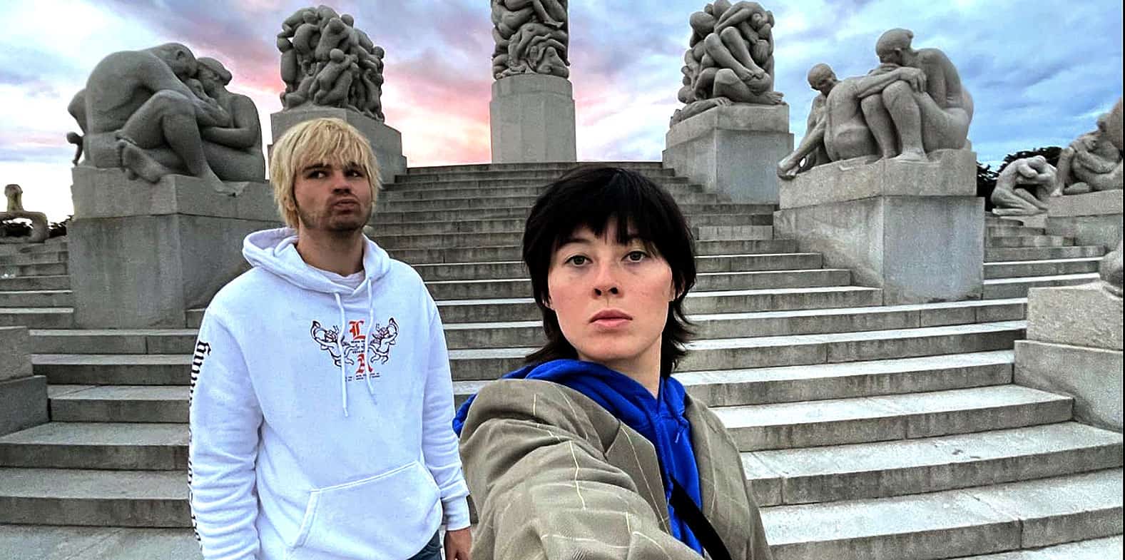 Vintage-inspired photograph of two young adults taking a selfie at the National Memorial Cemetery of the Pacific, also known as the Punchbowl Crater, showcasing iconic historical and memorial site of Honolulu, Hawaii.