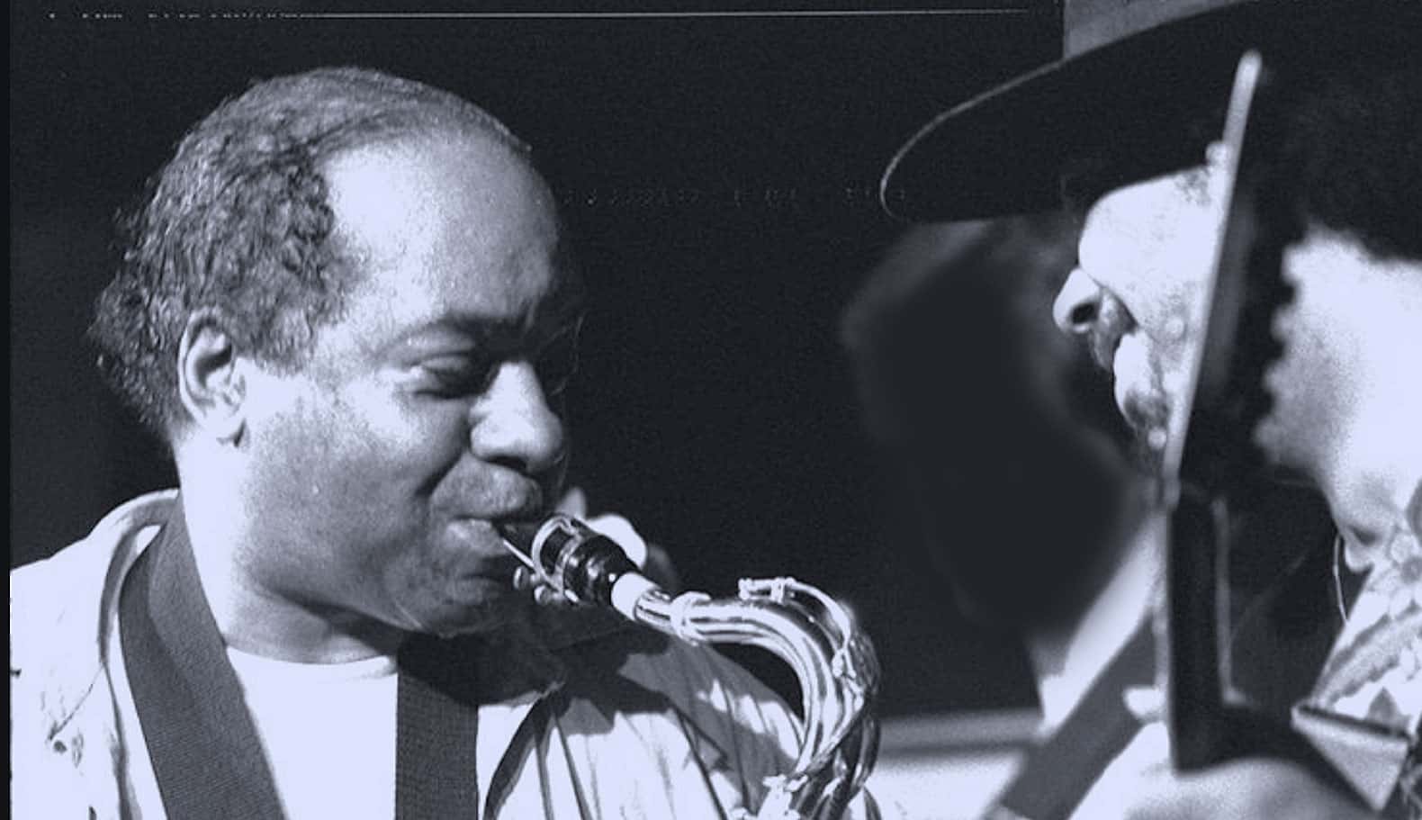 Vibrant black and white photo of jazz musicians playing saxophone and trumpet at a live concert, capturing the essence of jazz music, history, and cultural performances on Past Daily.