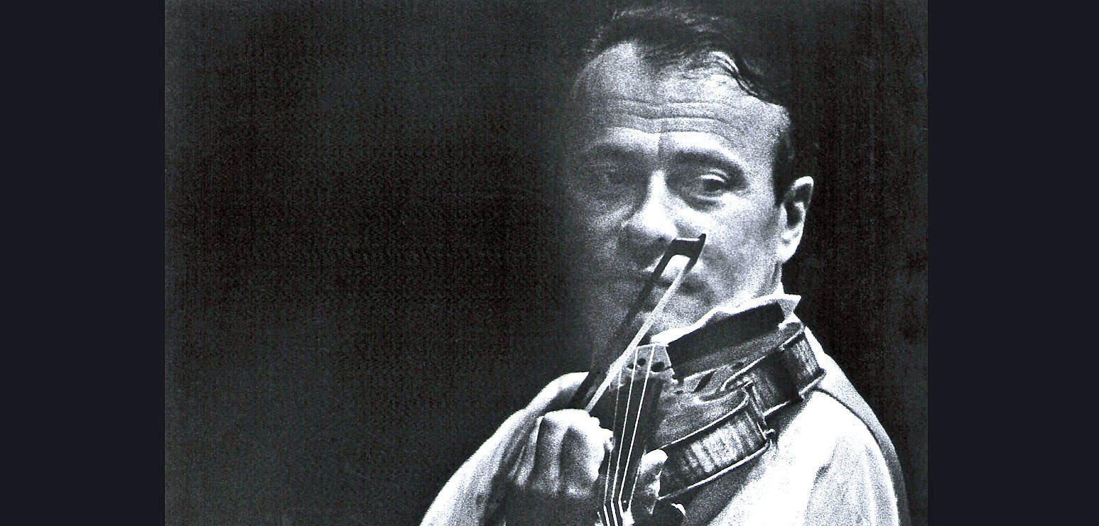 Vintage black and white photo of a man playing the violin, capturing a moment of musical performance with a focus on history, music preservation, and sound archive significance.