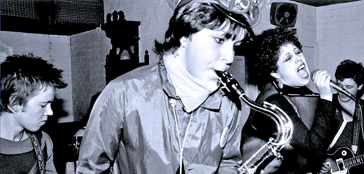 Vintage jazz band recording session with saxophonist, female vocalist, and guitarist, capturing classic music moments for history and nostalgia.