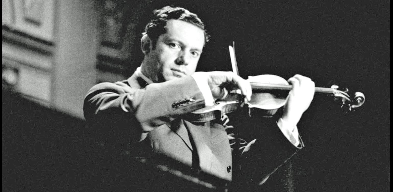 Vintage black and white photo of a man playing the violin, representing historical music recordings and classic performances, associated with the Past Daily sound archive of news, history, and music.