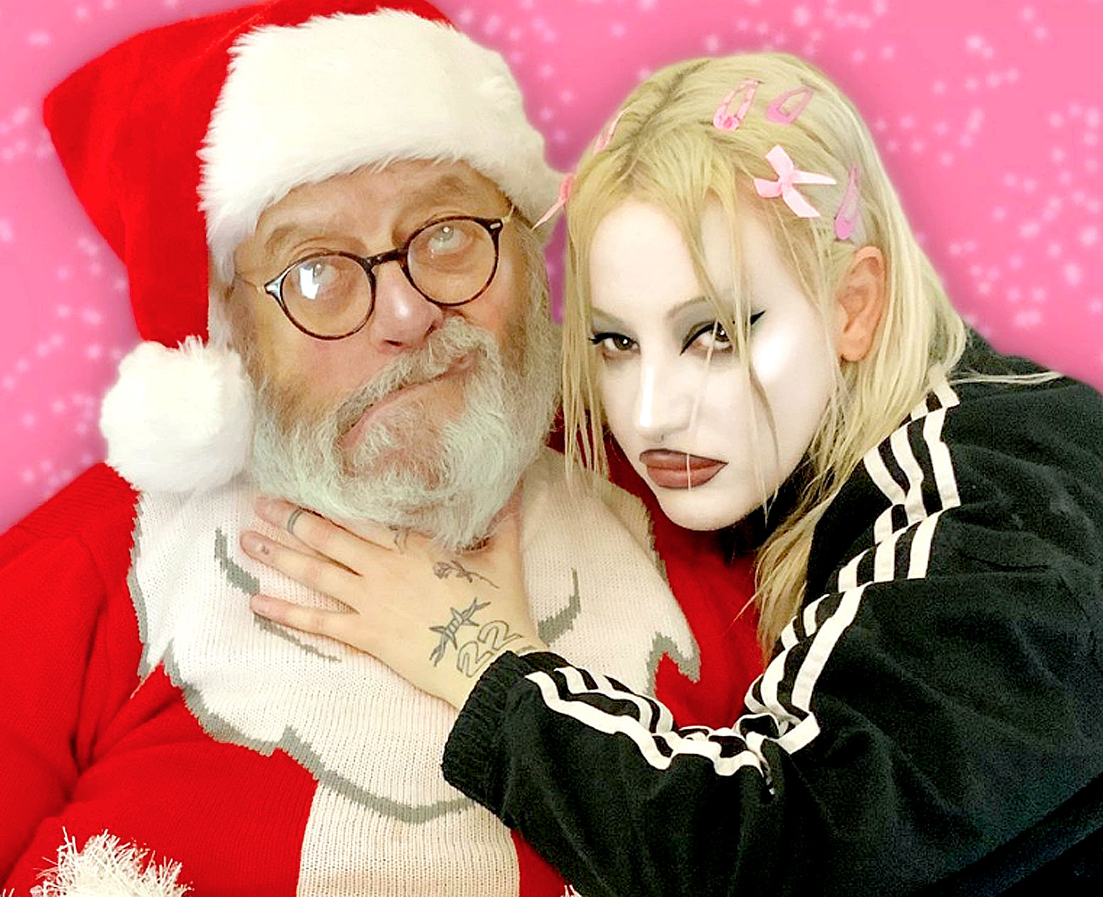 Santa Claus with blonde woman wearing pink hair clips, Christmas holiday themed image, festive season, holiday cheer, celebrating Christmas with music and news archive.
