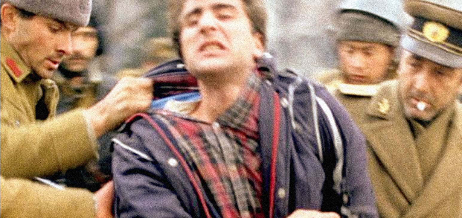 Man being assaulted by soldiers during a confrontation or protest, capturing a tense moment related to history, news, and social conflict.